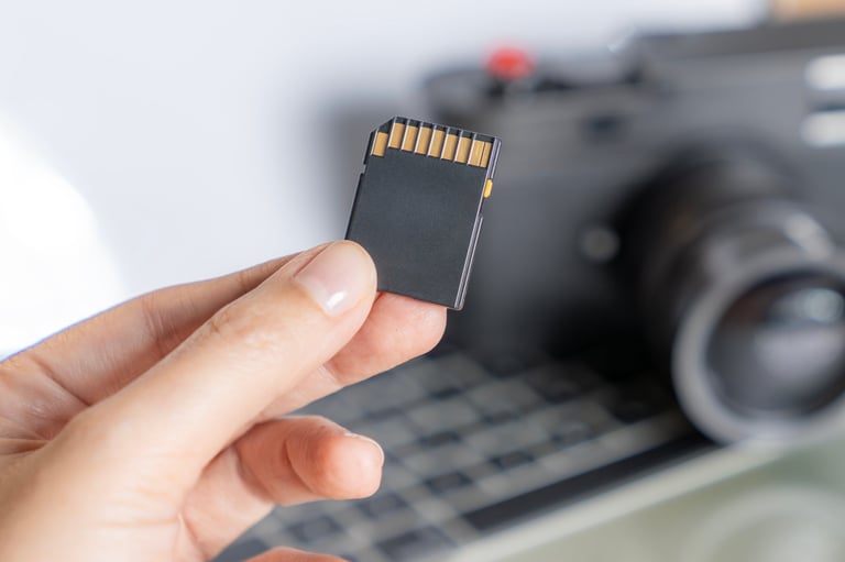 Close-up of a hand holding a digital camera memory card, representing data storage, photography equipment, and digital media technology.